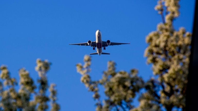 A large passenger jet flies over Floral Park in 2014,...