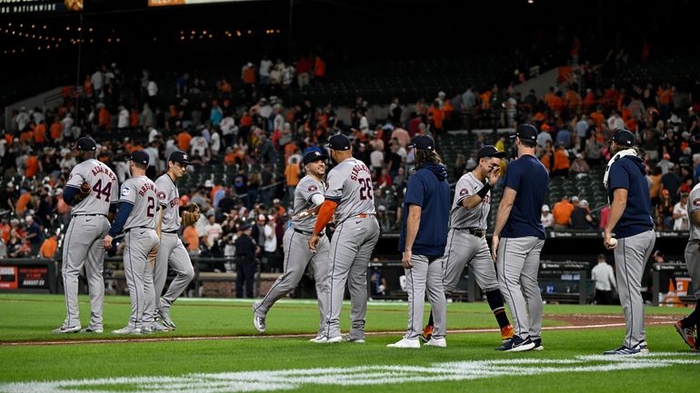 Houston Astros players greet each other after defeating the Baltimore...