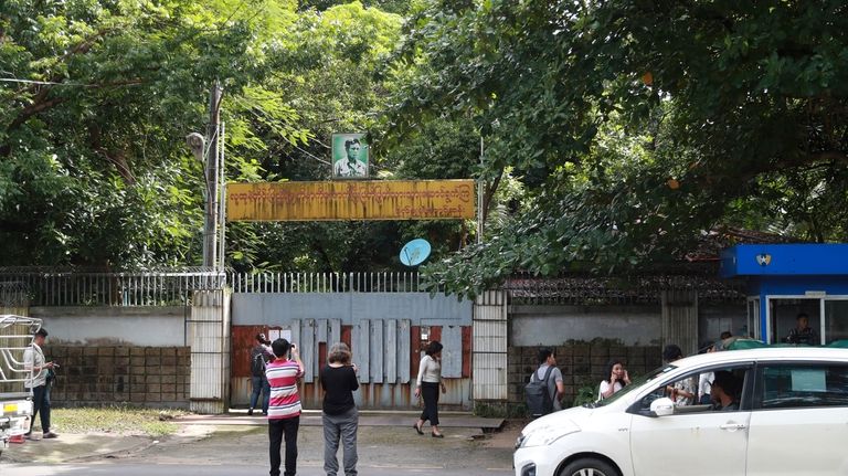 Journalists gather outside the residence of ousted leader Aung San...