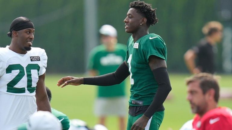 Jets' Sauce Gardner, right, talks with Breece Hall during practice...