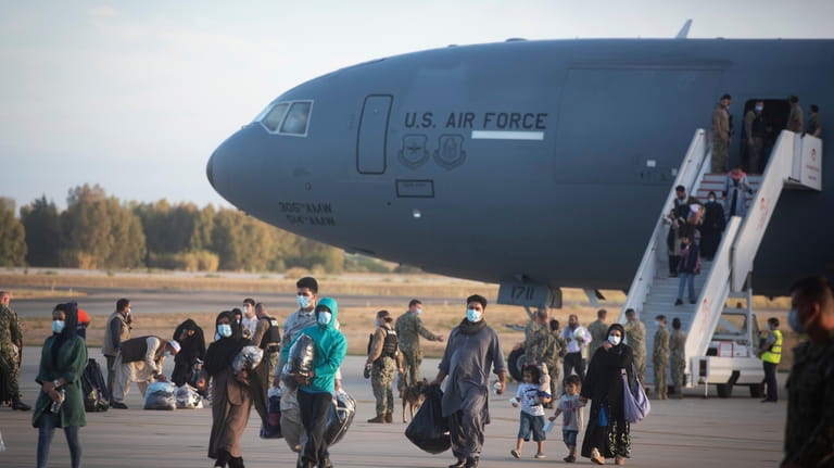 Evacuees from Afghanistan disembark from a U.S. airforce plane at...