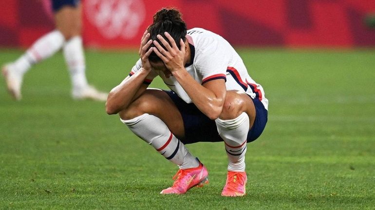 USA's forward Carli Lloyd (C) reacts to the loss to...