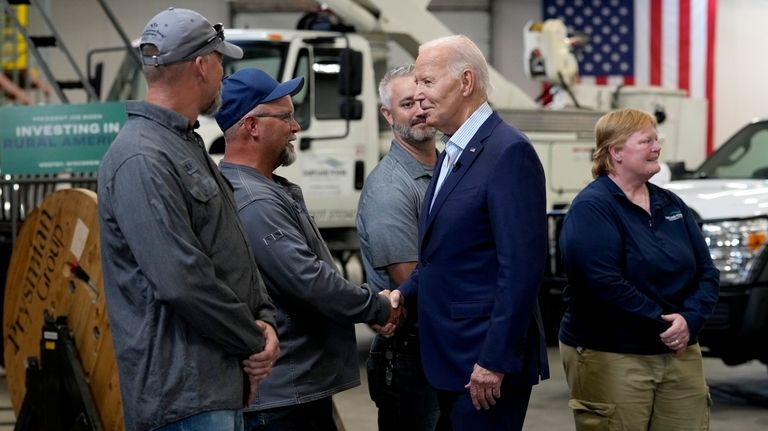 President Joe Biden, second from right, greets workers from Dairyland...