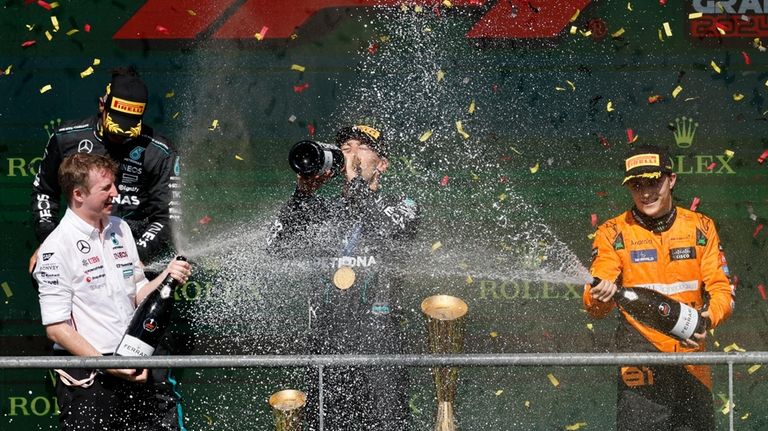 First place, Mercedes driver George Russell of Britain, center, celebrates...