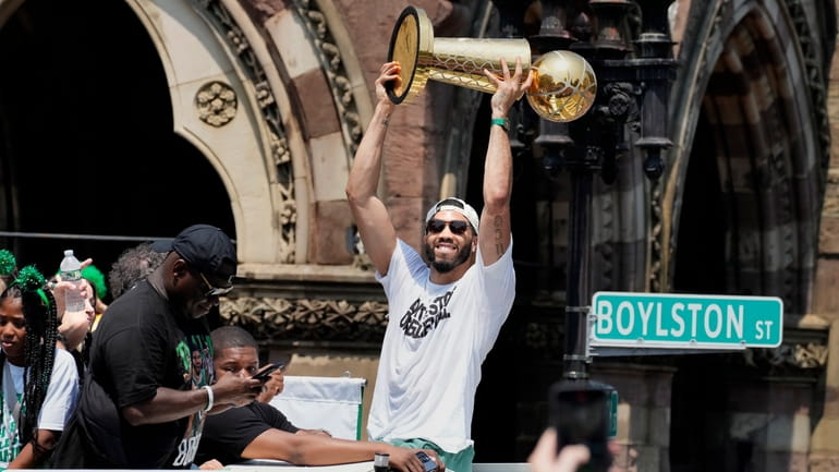 Boston Celtics' Jayson Tatum celebrates the team's NBA basketball championship...