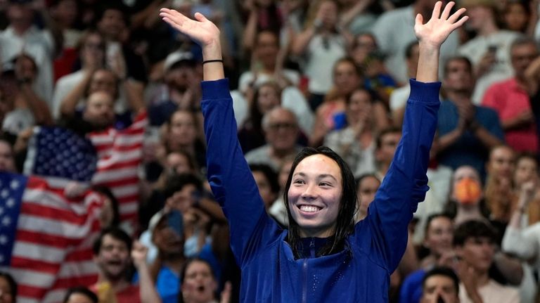 Torri Huske, of the United States, waves as she stands...