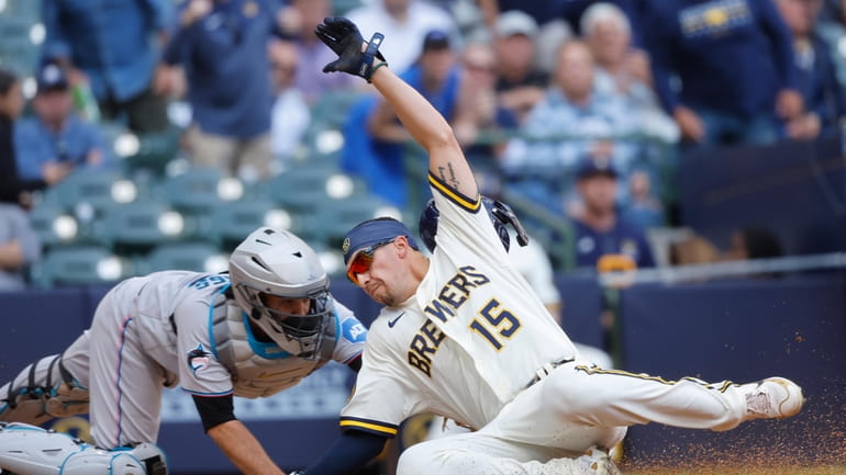Milwaukee Brewers' Tyrone Taylor (15) scores ahead of the tag...