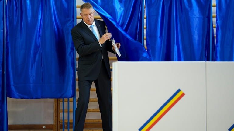 Romanian President Klaus Iohannis exits a voting cabin during European...