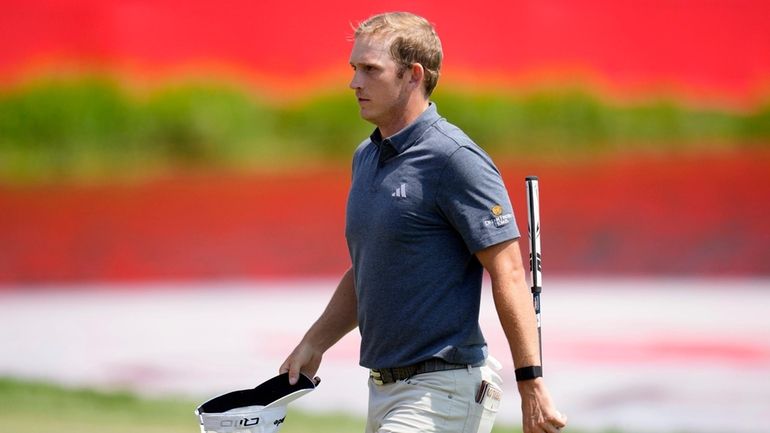 Jacob Bridgeman walks on the 18th green after making a...