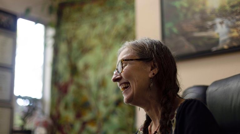 Cathy Jonas, owner of Epic Healing Eugene, laughs during an...