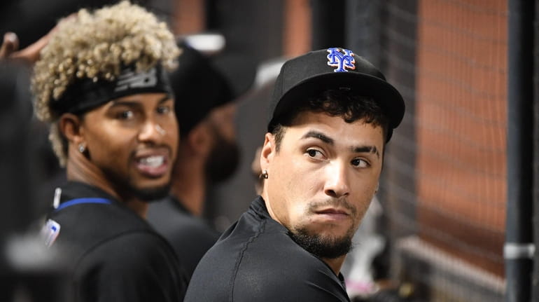 The Mets' Javier Báez and Francisco Lindor look on from...