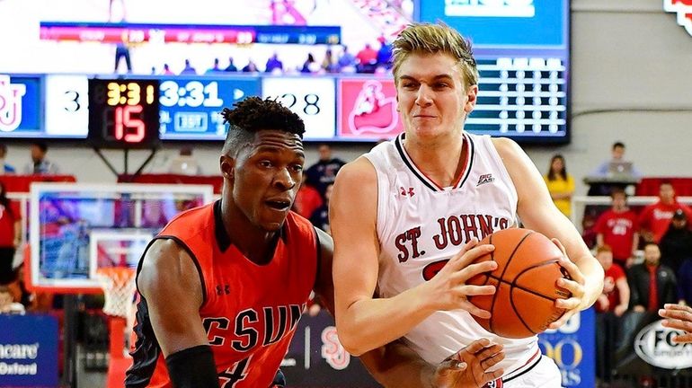 St. John's Richard Freudenberg, right, is defended by Tavrion Dawson...