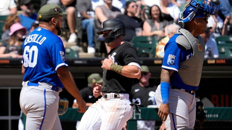 Chicago White Sox's Romy Gonzalez, center, scores on a sacrifice...