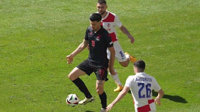 Albania's Mirlind Daku, centre, controls the ball ahead Croatia's Martin...