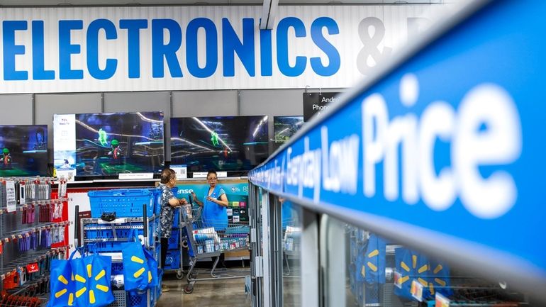 People walk around a Walmart Superstore in Secaucus, New Jersey,...