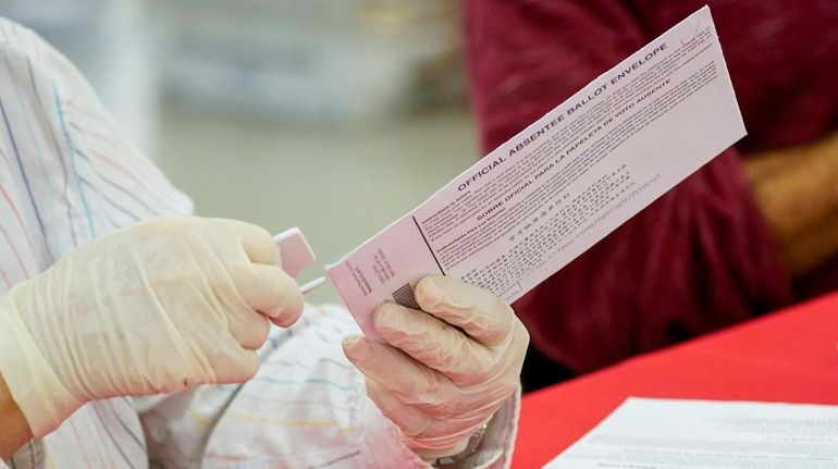 An NYC Board of Election staffer removes an absentee ballot...