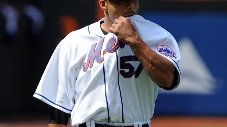 New York Mets' Johan Santana (57) wipes his face while...