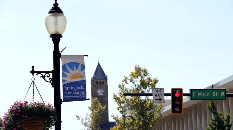 A sign hangs from a street light at the intersection...