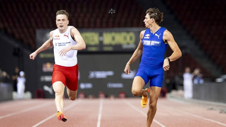 Armand Duplantis, right, of Sweden, crosses the finish line front...