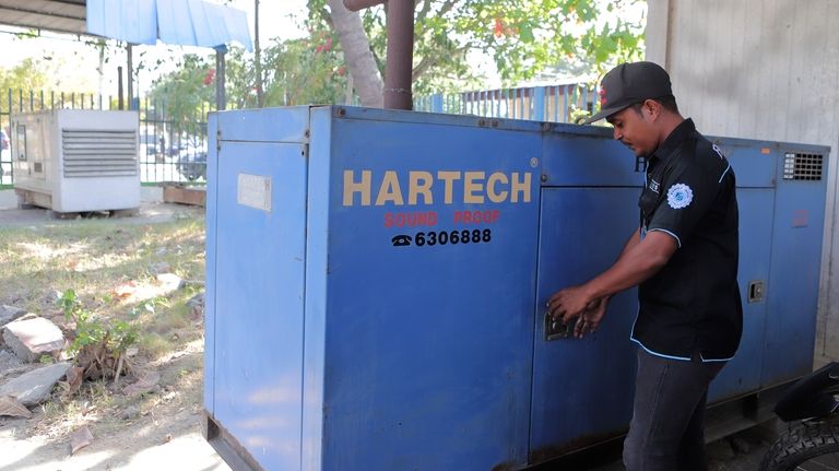 A man stands next to a generator at an office...