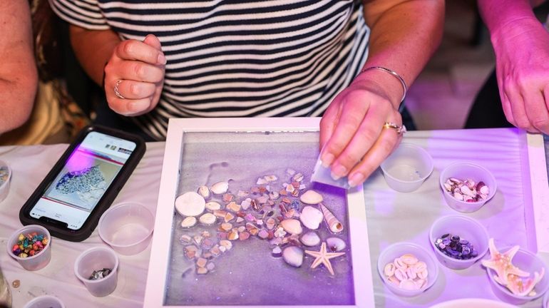 Jackie DiChristina, of Hauppauge, creates beach glass art during a...