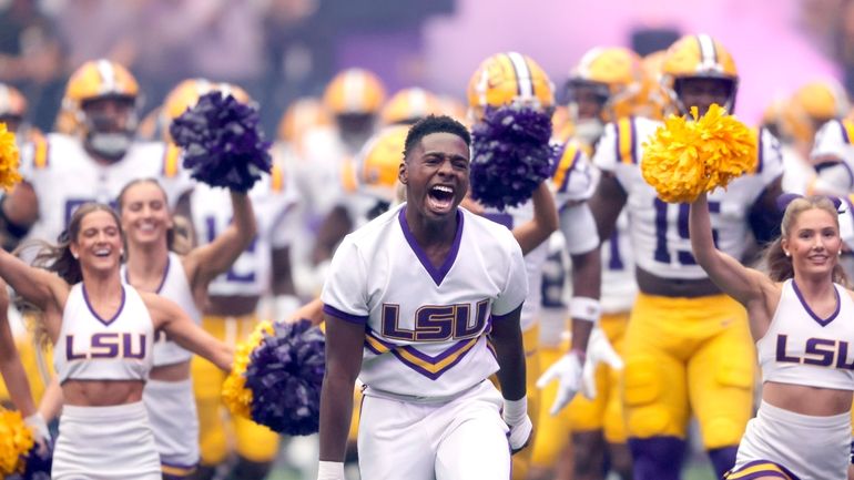 LSU cheerleaders lead players onto the field for an NCAA...