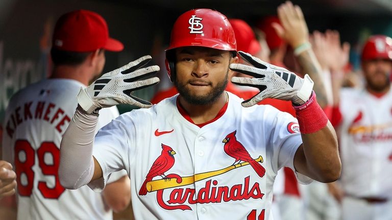 St. Louis Cardinals' Victor Scott II celebrates in the dugout...