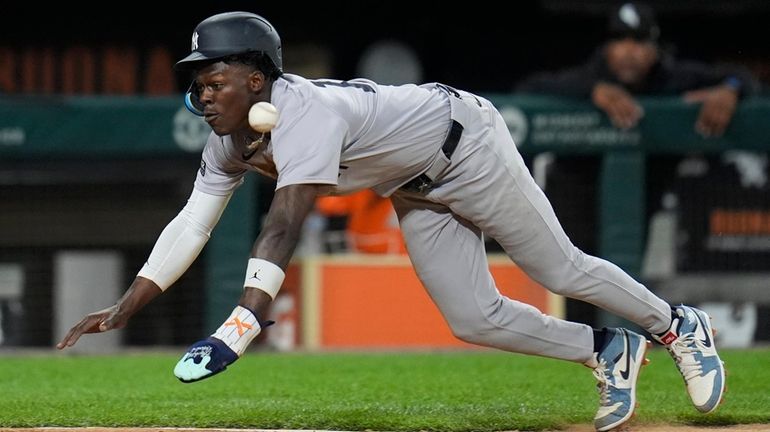 The Yankees' Jazz Chisholm Jr. dives safely into home base to...