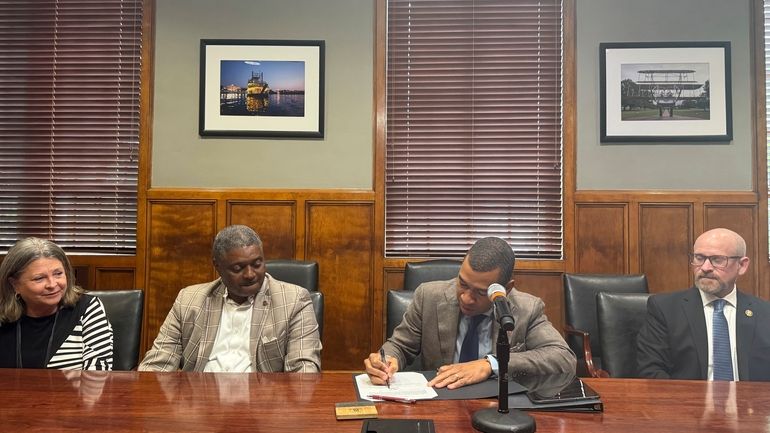 Montgomery Mayor Steven Reed signs a bill requiring photo ID...