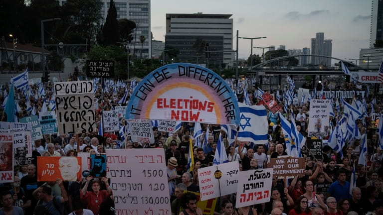 People attend a protest against Israeli Prime Minister Benjamin Netanyahu's...