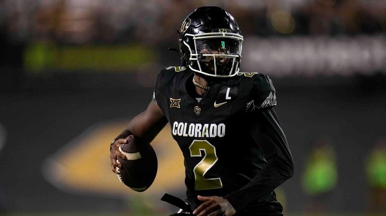 Colorado quarterback Shedeur Sanders scrambles during the second half of...