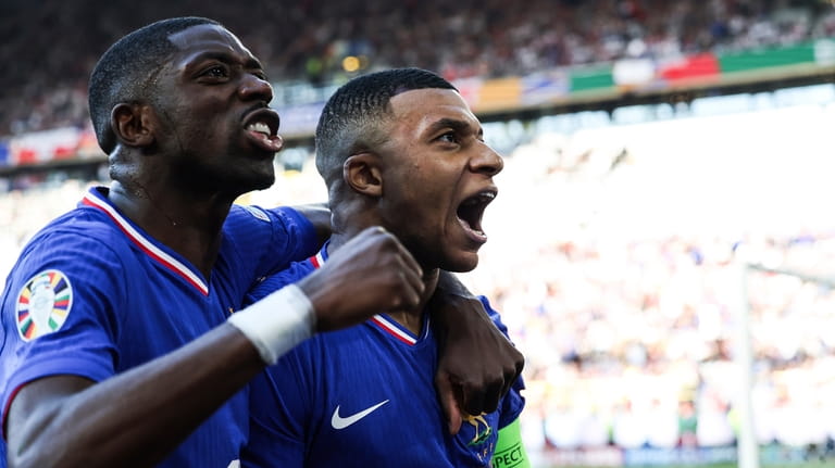 Kylian Mbappe of France, right, celebrates after scoring a penalty...