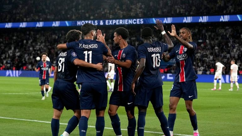 PSG's Marco Asensio, back to camera, celebrates with teammates after...