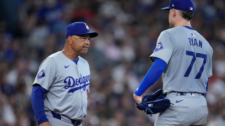 Los Angeles Dodgers manager Dave Roberts, left, pulls starting pitcher...