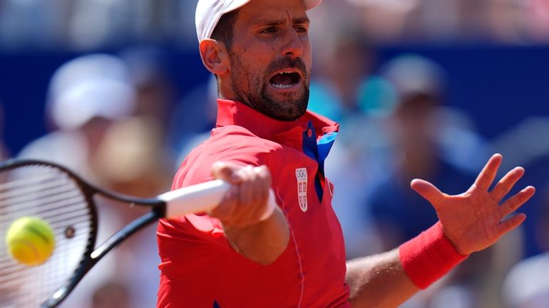 Serbia's Novak Djokovic slams a forehand to Spain's Rafael Nadal...