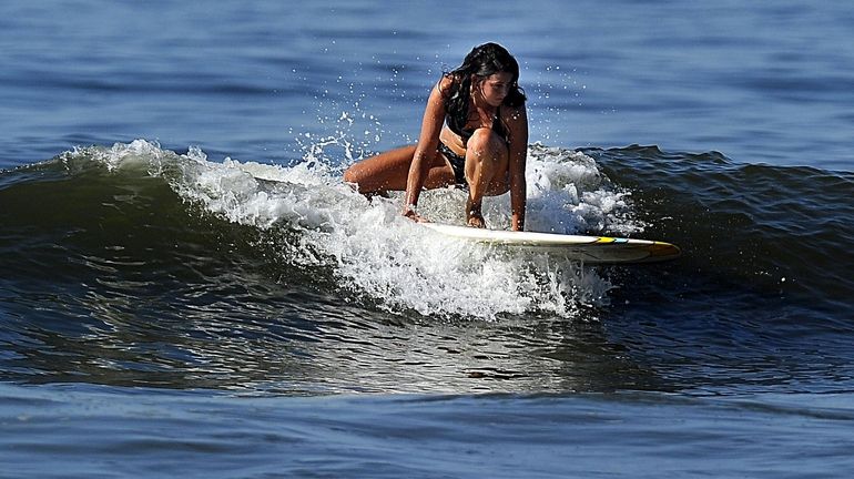 A surfer catches a wave in Long Beach. (Aug. 7,...