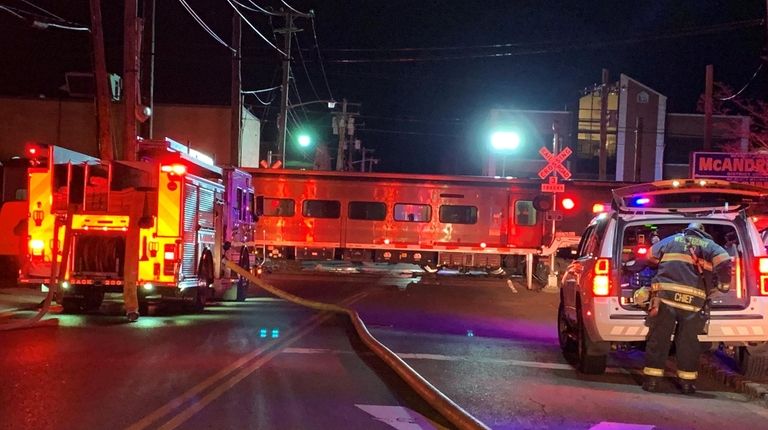 Firefighters at the scene in Westbury after a vehicle was hit by...