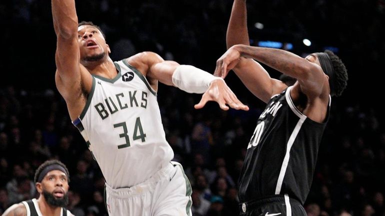 Giannis Antetokounmpo of the Bucks scores on Day'Ron Sharpe of the Nets...