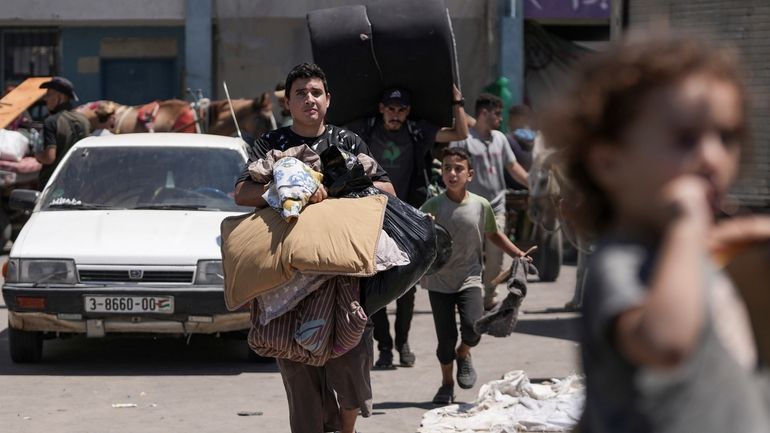 Palestinians evacuate a school that had been their shelter, in...