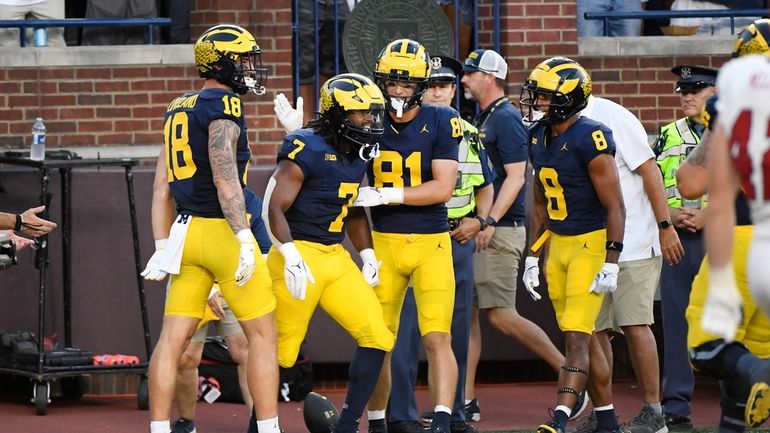 Michigan running back Donovan Edwards, second from left, celebrates his...