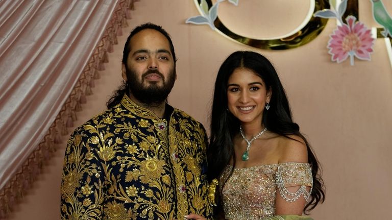 Anant Ambani, left, and Radhika Merchant pose for photographers during...