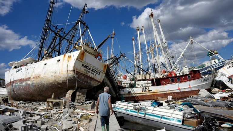 Bruce Hickey, 70, walks along the waterfront, now littered with...