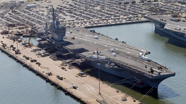 The nuclear-powered aircraft carrier USS Dwight D. Eisenhower sits pier...