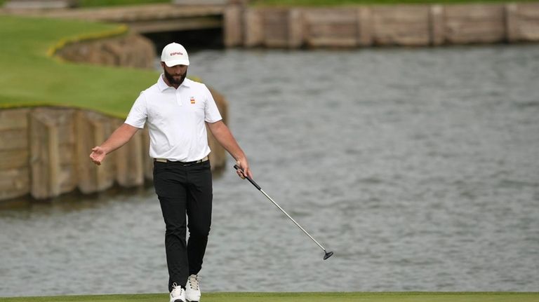 Jon Rahm, of Spain, reacts after missing a putt for...