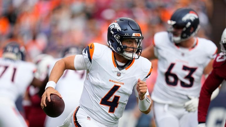 Denver Broncos quarterback Zach Wilson runs with the ball against...