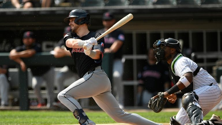 Cleveland Guardians' Lane Thomas watches his 2 RBI single during...