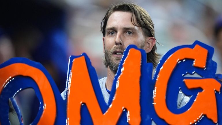 The Mets' Jeff McNeil holds up an "OMG" sign as...