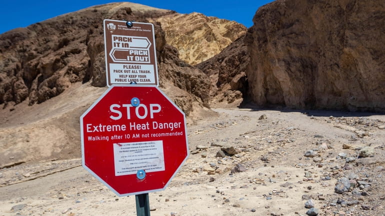 A sign warns hikers of extreme heat at the start...