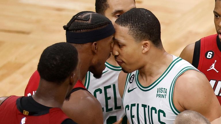 Miami Heat forward Jimmy Butler, center left, has words with...