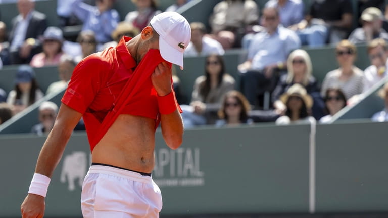 Novak Djokovic, of Serbia, wipe your eyes as he plays...